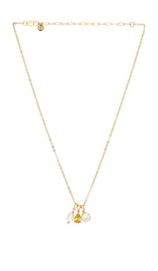 ettika dainty triple charm necklace in metallic gold.