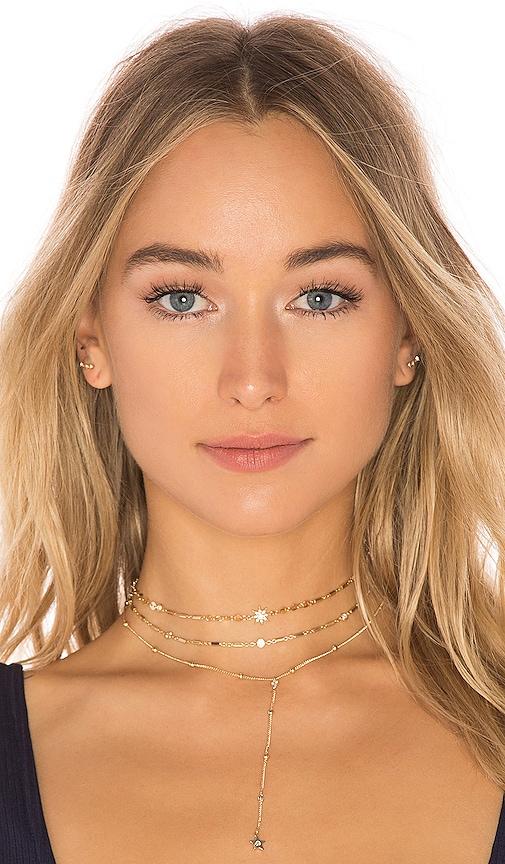 ettika forever falling multi-chain lariat choker in metallic gold.