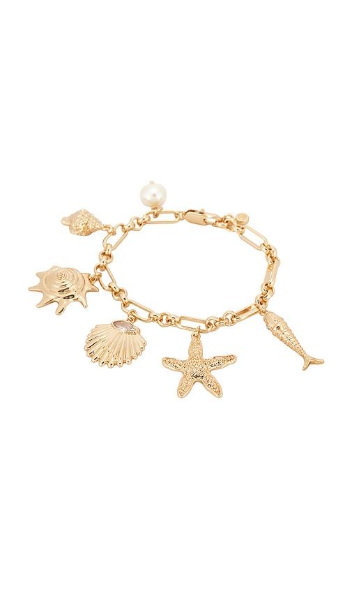 ettika oceanic dreams charm bracelet in metallic gold.